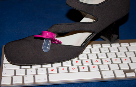 Hoher Schuh mit Schnuller auf Tastatur